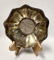 Front view of the vintage scalloped silver plated bowl highlighting the embossed scenic medallion on the bottom.