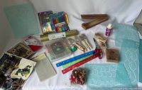 Overview photo showing all craft items including gel pens, paintbrushes, stencils, rulers, stamps, scissors, glue bottle, and embellishments arranged on white background.