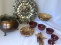 Photo of the entire lot showing copper pot, metal tray, nested measuring bowls, pottery bowl, wooden plate and wood carving