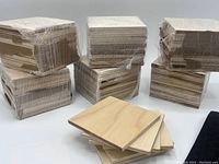 Six stacks each containing 12 unfinished pine square coasters wrapped in plastic packaging, totaling 72 coasters.