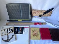 Contains all items in the lot: paper cutter, kraft paper roll, three notebooks, quill pen with ink, photo paper, pad of framable quotes.