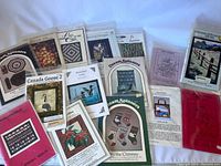 Lot of multiple quilting pattern booklets laid flat including Dream Spinners and Canada Goose 2 designs with visible colorful quilt samples on cover