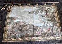 Picture showing full tapestry with attached border, rod, brackets, and finials laid flat to display size and mounting hardware.