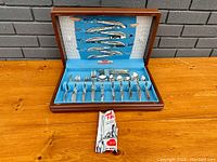 Box open showing knives in lid and utensils in base