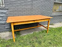 Full view of the antique pine harvest table with rectangular top and stretcher base