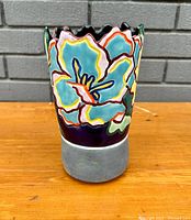 Front view of the planter showing colorful floral design and scalloped rim