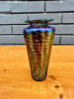 Front and side profile view of iridescent art glass vase showing spiral pulled feather design and flared lip.