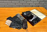 Twelve pairs of vintage womens gloves arranged on wooden table, showing leather and winter styles including black, brown, beige, and patterned types.