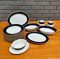 Overall view of complete Noritake Valhalla pattern bone china dinnerware collection on table, showing plates, platters, and serving accessories.