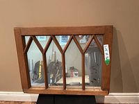 Front view of pine framed window mirror with multiple vertical and angled muntins creating a decorative arch pattern.