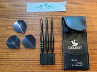 Top view of three darts, three flights, and black carrying case with 'Elkadart' and 'Black Knight 20 Gram APP' label.