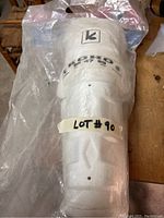 Koho SR 47 SG hockey shin pad inside clear plastic bag with lot number tape.