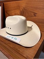 Side and top view of the ladies white western cowboy hat showing the curved brim, black band, and ventilation eyelets.