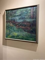 Framed painting hanging on wall showing natural forest scene with orange day lilies under tall trees. Good detail of composition and color.