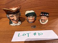 Three Royal Doulton miniature character mugs displayed side by side with a coin for size reference.