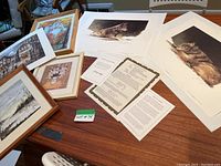 Photo showing two limited edition Timber Wolf prints by Morten Solberg alongside framed paintings and other prints on a table, including authenticity certificates and lot number visible.