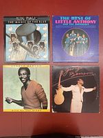 Photo showing four vintage vinyl record album covers. Top left: Blue Magic 'The Magic of the Blue'. Top right: The Best of Little Anthony and The Imperials. Bottom left: George Benson 'Give Me the Night'. Bottom right: George Benson album with guitar and arms outstretched on cover.