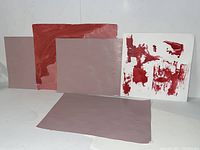 Five acrylic paintings on paper arranged side by side displaying abstract designs primarily in shades of red and pink, with one featuring a white background and bold red strokes.