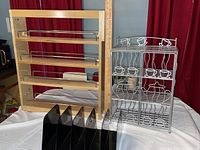 Three items on display together: wooden kitchen shelf, metal coffee and tea cabinet with cup and teapot design, and black office organizer