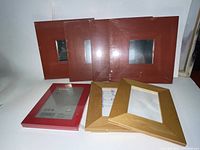 Eight pieces of IKEA wood frame wall art mirrors in red and natural wood, some with mirrors installed, some empty frames shown together on white background.