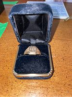 Front view of the 10K gold ring inside black velvet box showing the ring shape and box interior.