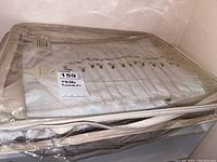 The entire folded tablecloth and napkins set packed in a clear zippered plastic bag showing part of the embroidery