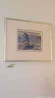 Framed print of a stormy landscape showing the whole frame and wall label with size 11 x 13.5