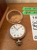 Full view of open pocket watch showing dial and case