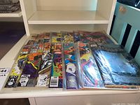 Overall view of the collection showing multiple comic books in plastic sleeves including Spider-Man and Superman
