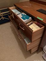 Two wooden drawers open showing multiple boxed PartyLite candles and accessories inside.