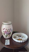 Full view of the Portmerion vase and Royal Worcester flan dish placed on wooden table