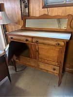Full view of antique dry sink showing wood, mirror frame, two drawers, double doors, and bottom drawer