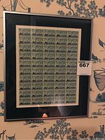 Full framed sheet of multiple 3 cent SOO Locks 1855-1955 stamps behind glass.