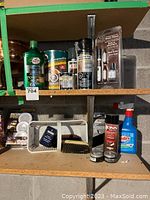 Shelf with assorted household products including Turtle Wax, spray paint, wood touch up kits, shoe care items, Nu Finish car wax, Drano, Windex, Motion Pods, and Bonin leather cleaner.