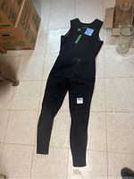 Full view of the black Ronstan wetsuit laid flat on floor showing sleeveless, high neck design and knee patches.