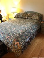 Full assembled queen bed with wooden headboard, metal frame, comforter, pillow shams and bedskirt