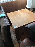 Teak end table shown beside furniture and lamp, highlighting overall structure and condition.