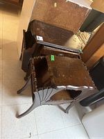 Photo showing two vintage wooden end tables stacked, highlighting wood surface wear and structural design.