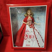 Front view of 2010 Holiday Barbie doll in box showcasing the doll's dress, shawl, and winter background.