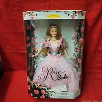 Front view of Rose Barbie Doll in original packaging showcasing the pink rose-themed dress and floral box design.