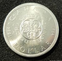 Reverse side of 1964 Canadian silver dollar showing floral design and 'CANADA DOLLAR 1964' inscription.