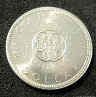 Reverse side of the 1964 Canadian silver dollar showing Canadian floral emblem with inscriptions.