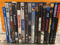 Front view of 16 assorted movie DVD and Blu-ray cases standing vertically, showing titles and covers.