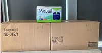 Two cardboard boxes each labeled '6 bags of 16 NU-012/1' with one bag of Prevail Nu-Fit disposable underpads placed on top of one box for display.