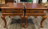 Pair of cherry or mahogany wood side tables with single drawers, cabriole legs, and scalloped aprons shown from front top-down angle.