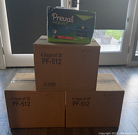 Three sealed cardboard boxes each labeled PF-512 containing 4 bags of Prevail Per-Fit Adult Unisex Daily Underwear/Diapers size Medium 34-46. One bag removed and placed on top for display only.