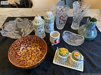 Photo showing entire lot including crystal bowls, ceramic floral jars, vintage salt & sugar set, fish planter, and decorative bowls.