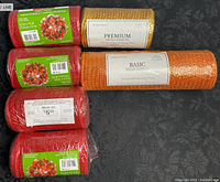 Photo of six rolls of decorative mesh ribbons in red, orange, and gold colors, showing size labels and packaging details