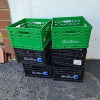 Front stacked view of crates showing Kool Krates logo and colors; 4 black and 2 green crates stacked; price stickers present on black crates.
