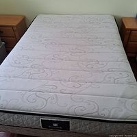 Full top view of the Sealy mattress on the bed frame with nightstands on both sides.